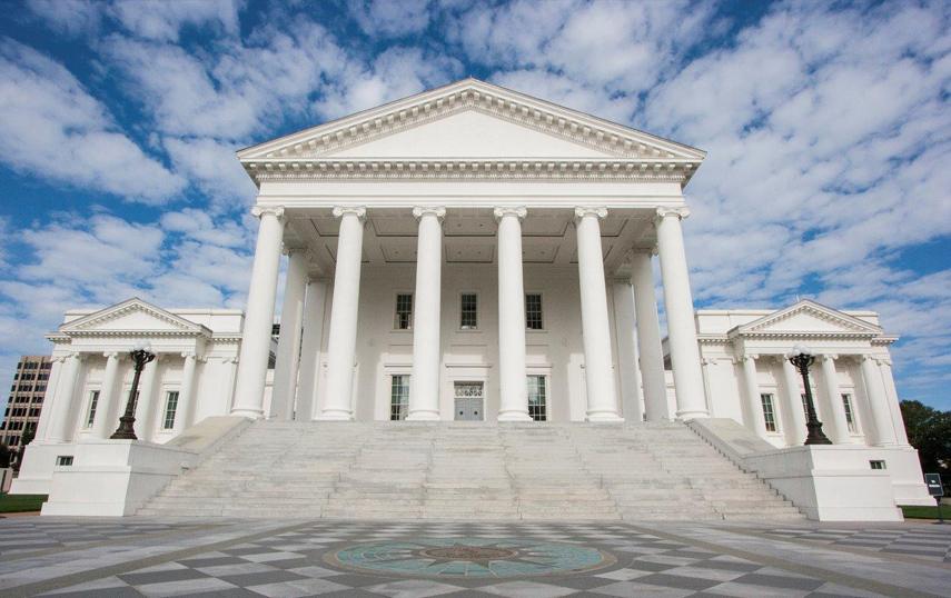 ሰማያዊ ሰማይ እና ነጭ ደመናዎች የVirginia Capitol ሕንፃን ይገልፃሉ